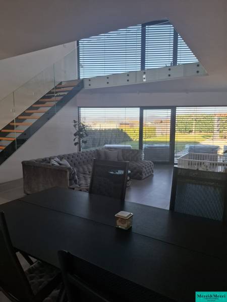 Moderný rodinný dom so záhradou, bazénom a nadštandardným priestorom - Jedálenský stôl a schodisko v rodinnom dome s výhľadom do záhrady.