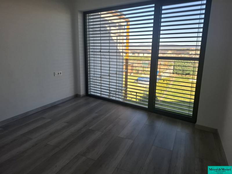 Moderný rodinný dom so záhradou, bazénom a nadštandardným priestorom - Interiér v rodinnom dome s veľkými oknami a podlahou s dreveným dekorom.