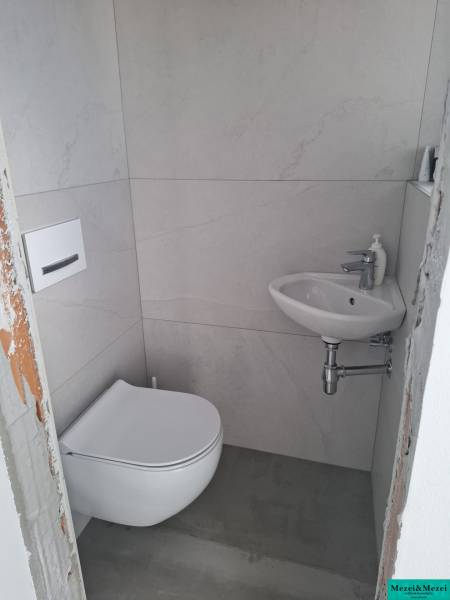 Moderný rodinný dom so záhradou, bazénom a nadštandardným priestorom - Malá kúpeľňa v rodinnom dome s práčkou a umývadlom.