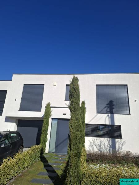 Moderný rodinný dom so záhradou, bazénom a nadštandardným priestorom - Rodinný dom v Zvončíne s minimalistickou fasádou a upravenou predzáhradkou.