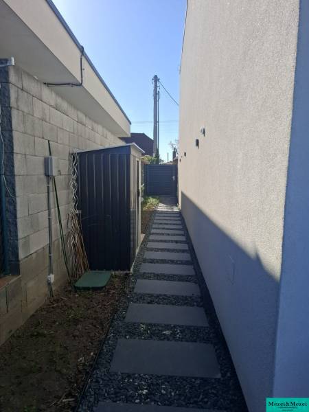Moderný rodinný dom so záhradou, bazénom a nadštandardným priestorom - Úzka bočná cestička so štrkom v Rodinnom dome v Zvončíne.