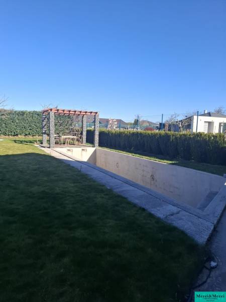 Moderný rodinný dom so záhradou, bazénom a nadštandardným priestorom - Záhrada rodinného domu v Zvončíne s pergolou a nedokončeným bazénom.