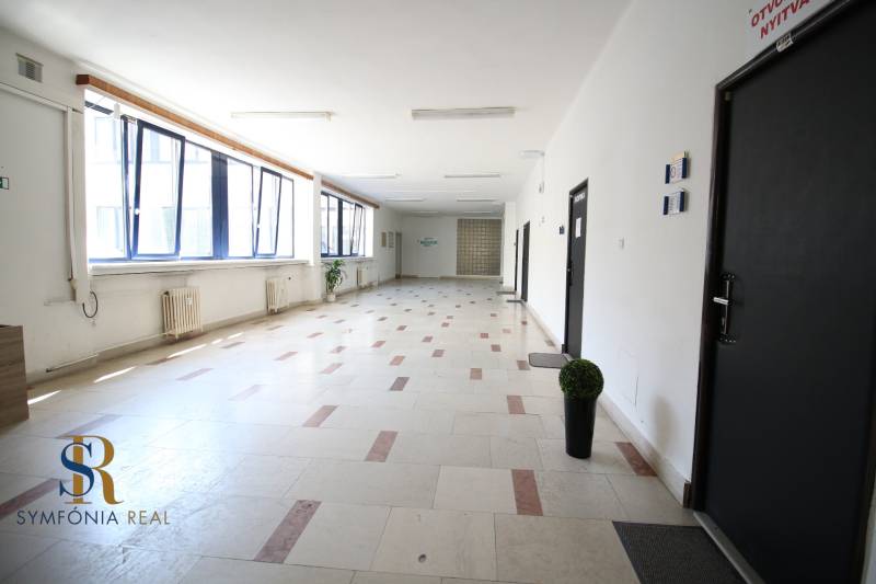Prenájom centrum Galanty - Chodba v kanceláriách s veľkými oknami a dlaždicovou podlahou.