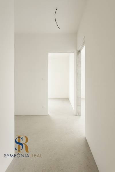 4-izbový rodinný dom Galanta – HODY - bez rezervačnej zálohy - Prázdny interiér rodinného domu s bielymi stenami a betónovou podlahou.