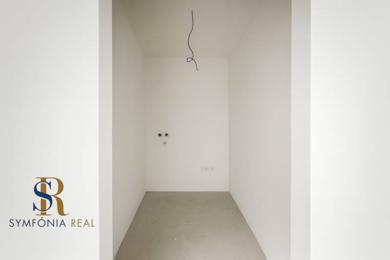 4-izbový rodinný dom Galanta – HODY - bez rezervačnej zálohy - Prázdna miestnosť v rodinnom dome s bielymi stenami a betónovou podlahou.