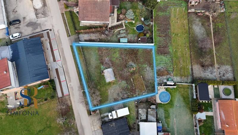 Pozemok na stavbu domu v Pate – 811 m² - bez rezervačnej zálohy - Letecký pohľad na pozemok na bývanie v Pate, ohraničený modrou čiarou.