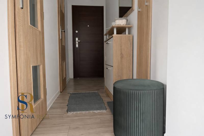 NOVINKA - Priestranných 74 m² v štýlovo zariadenom byte - Chodba v 3-izbovom byte s podlahou s dreveným dekorom, so zrkadlom a úložným priestorom.