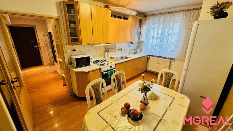 Na predaj 3 i  byt s loggiou aj terasou - Prievidza 75,24 m2 - Kuchyňa v 3-izbovom byte s podlahou s dreveným dekorom a jedálenským stolom.