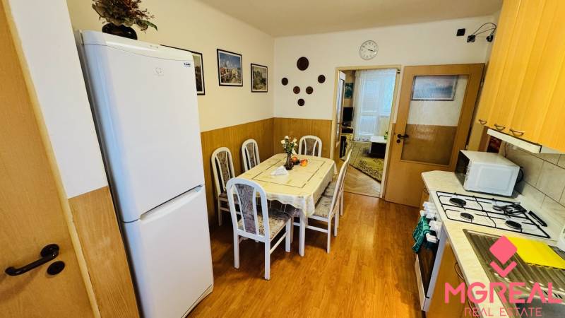 Na predaj 3 i  byt s loggiou aj terasou - Prievidza 75,24 m2 - Kuchyňa v 3-izbovom byte s jedálenským stolom a podlahou s dreveným dekorom.