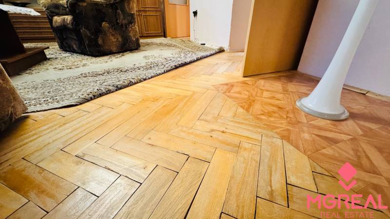 Na predaj 3 i  byt s loggiou aj terasou - Prievidza 75,24 m2 - Podlaha s dreveným dekorom v 3-izbovom byte, koberec a nábytok v interiéri.