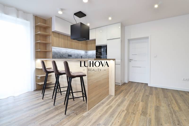 Na PRENÁJOM_v NOVOSTAVBE krásny 3-izbový byt s parkovacím státím - Kuchyňa v 3-izbovom byte s barovým pultom a podlahou s dreveným dekorom.