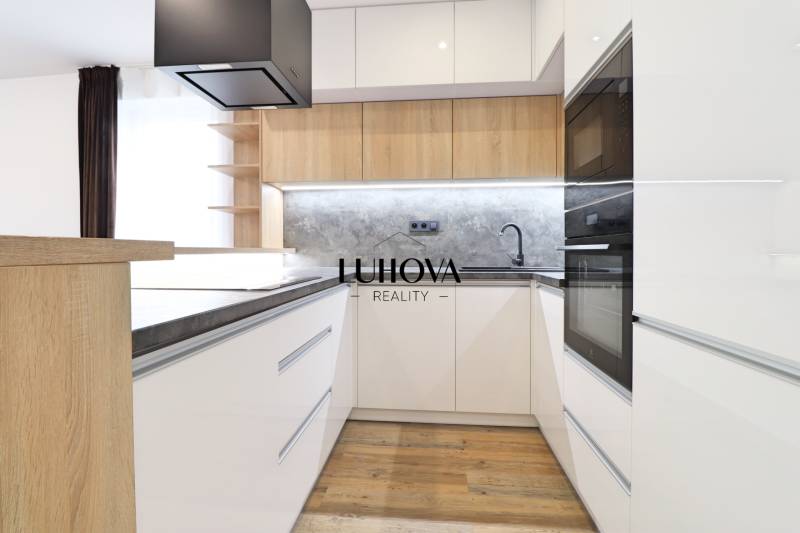 Na PRENÁJOM_v NOVOSTAVBE krásny 3-izbový byt s parkovacím státím - Kuchyňa v 3-izbovom byte s bielymi skrinkami a podlahou s dreveným dekorom.