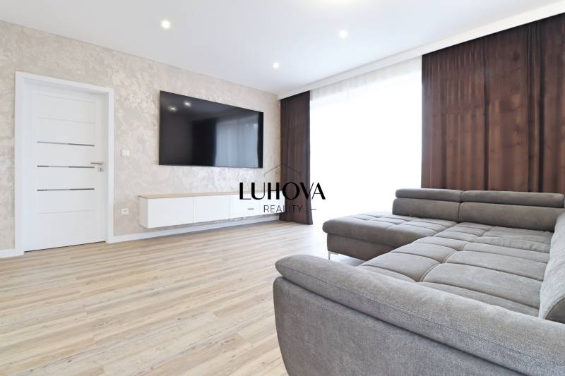 Na PRENÁJOM_v NOVOSTAVBE krásny 3-izbový byt s parkovacím státím - Obývacia izba v 3-izbovom byte s pohovkou a podlahou s dreveným dekorom.