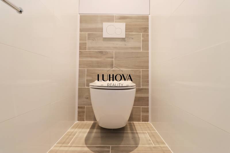 Na PRENÁJOM_v NOVOSTAVBE krásny 3-izbový byt s parkovacím státím - Toaleta s dreveným dekorom a bielymi obkladmi v 3-izbovom byte.