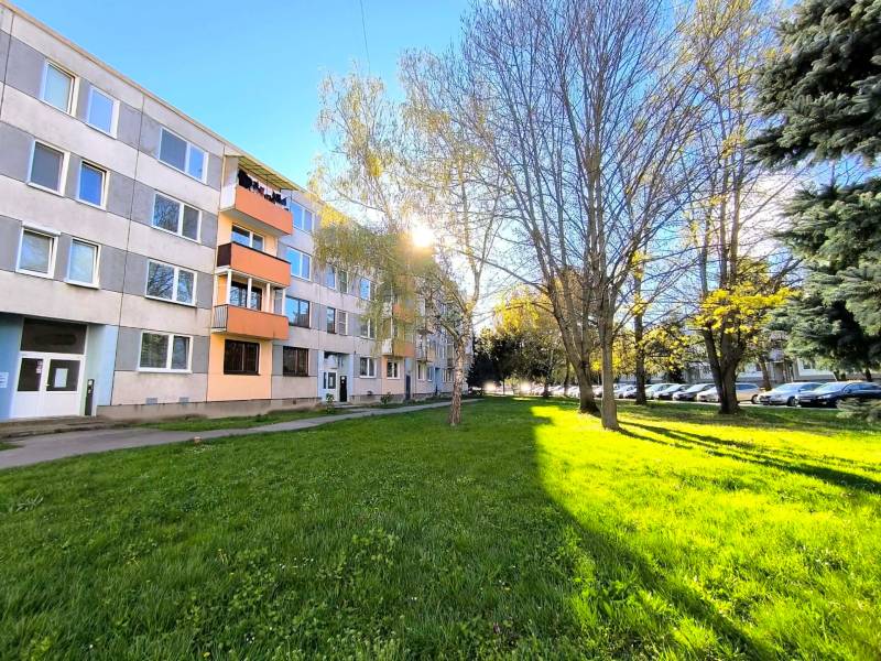 ‼️ PARTIZÁNSKE - 3,5 IZBOVÝ BYT NA PREDAJ, VEĽKÁ OKRUŽNÁ ‼️ - Panelový dom na Veľkej Okružnej v Partizánskom obklopený zeleňou a zaparkovanými autami.