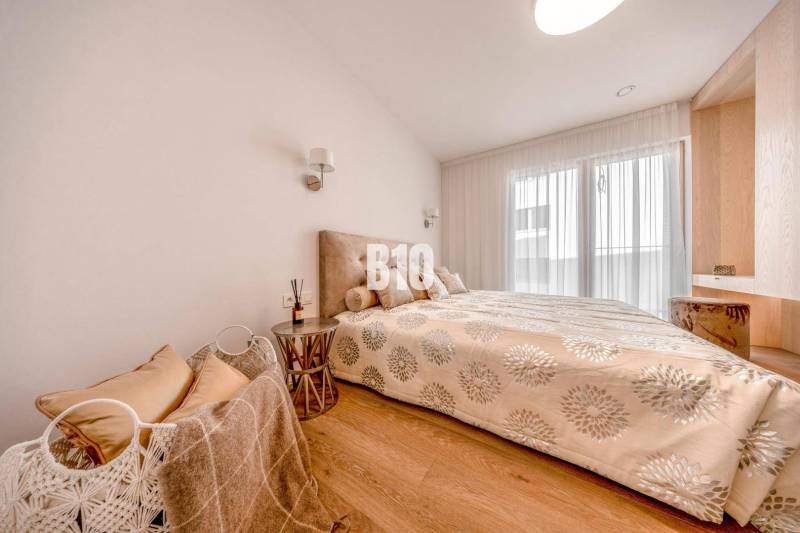 LUXUSNÝ 3-IZBOVÝ BYT NA MIERU V NADČASOVEJ NOVOSTAVBE NA ZAČIATKU KOLI - Spálňa v 3-izbovom byte s posteľou a podlahou s dreveným dekorom.