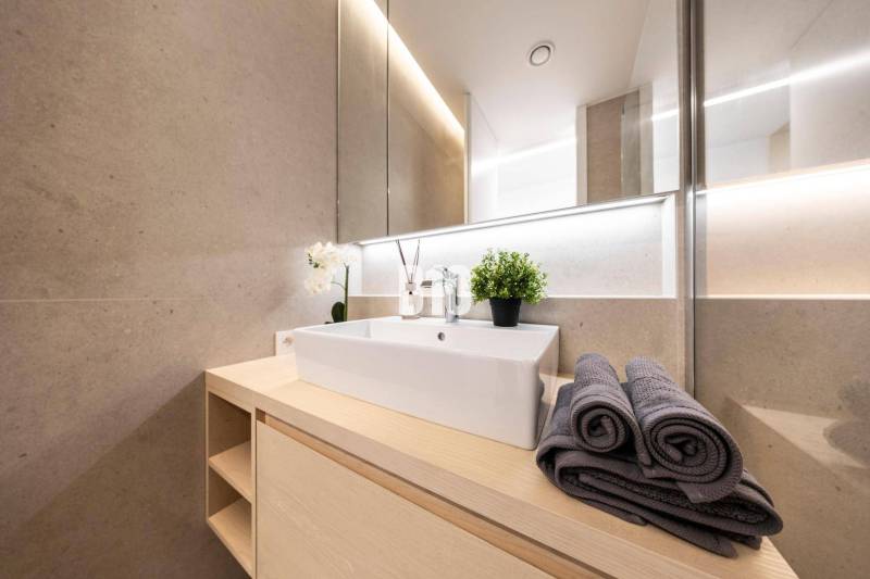 LUXUSNÝ 3-IZBOVÝ BYT NA MIERU V NADČASOVEJ NOVOSTAVBE NA ZAČIATKU KOLI - Kúpeľňa s moderným umývadlom, uterákmi a dekoráciou v 3-izbovom byte.