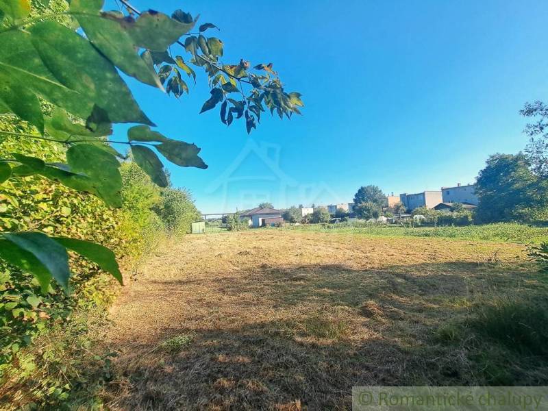 Stavebný pozemok pri Nitre so stavebným povolením v tichej lokalite - Pokojná zelená parcela na bývanie v Hosťovej obklopená prírodou a susediacimi domami.