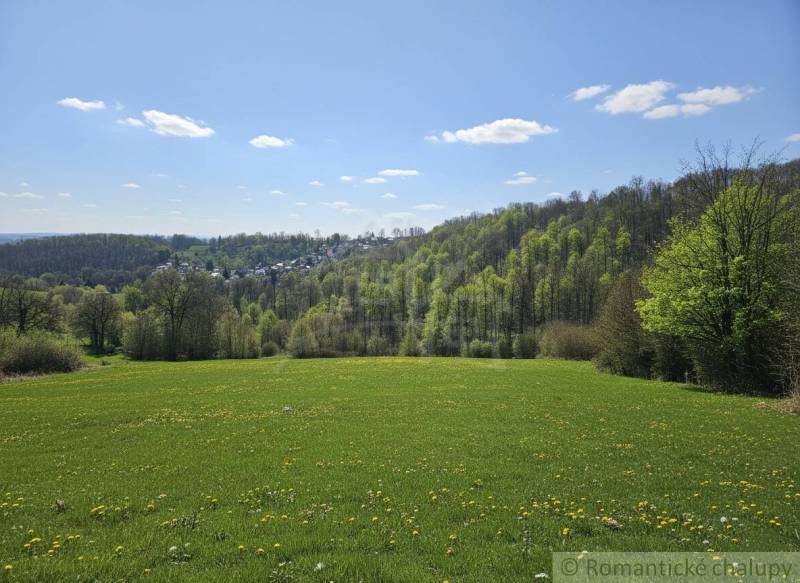 Vaša vlastná oáza na lazoch: Pozemok s dušou a krásnym výhľadom - Jarná krajina v okolí Krupiny, Pozemky - bývanie, zelené lúky a lesy na horizonte.