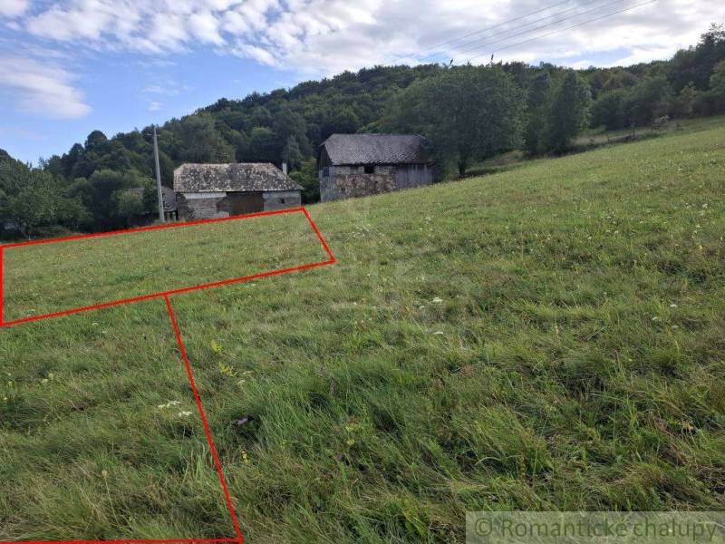 Veľký pozemok v srdci prírody pri Hornom Tisovníku - Pozemky - bývanie, Horný Tisovník. Trávnatá plocha s vidieckou budovou a lesnatým kopcom v pozadí.