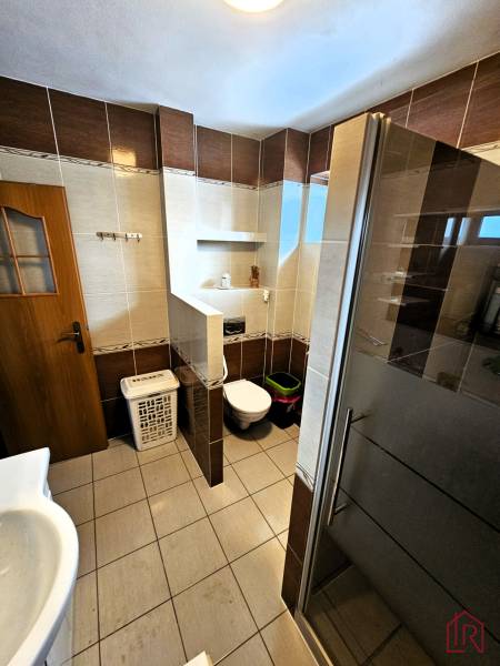 Predaj 5-izbový dom v Kameňanoch, okres Revúca - Kúpeľňa v rodinnom dome s dlažbou, sprchou a toaletou.