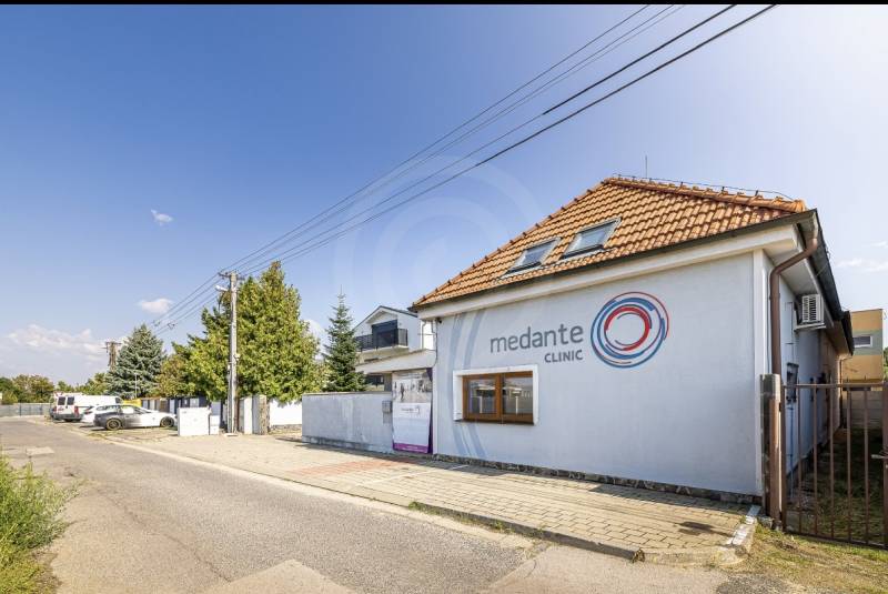 Na predaj dom ktorý môže slúžiť na podnikanie alebo bývanie vo Vrakuni - Rodinný dom na ulici Podpriehradná v Bratislave-Vrakuni s logom kliniky.
