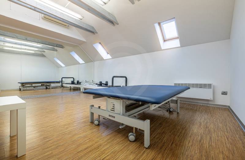 Na predaj dom ktorý môže slúžiť na podnikanie alebo bývanie vo Vrakuni - Fyzioterapeutická miestnosť v rodinnom dome s podlahou s dreveným dekorom a zrkadlami.