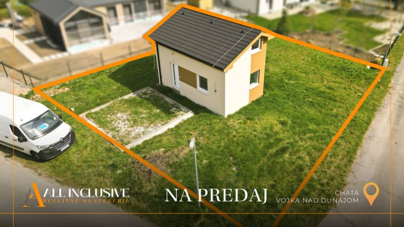 Na predaj rekreačný dom pri jazere, Vojka nad Dunajom - Chata vo Vojke nad Dunajom na priestrannom pozemku, ohraničená cestou a dodávkou.
