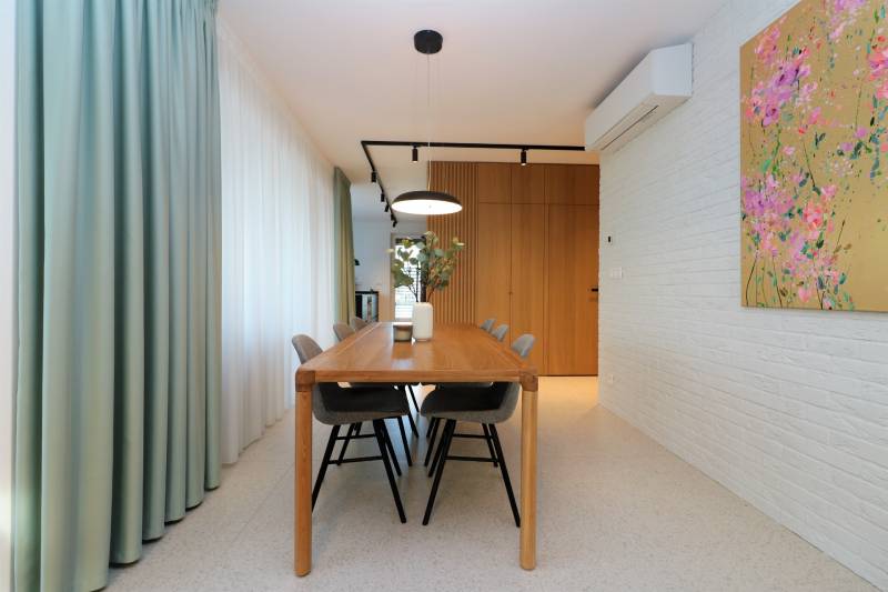 NUERA︱Penthouse s terasou s krásnymi výhľadmi v Dúbravke - Jedáleň vo 4-izbovom byte s dreveným stolom a dekoratívnou maľbou na stene.