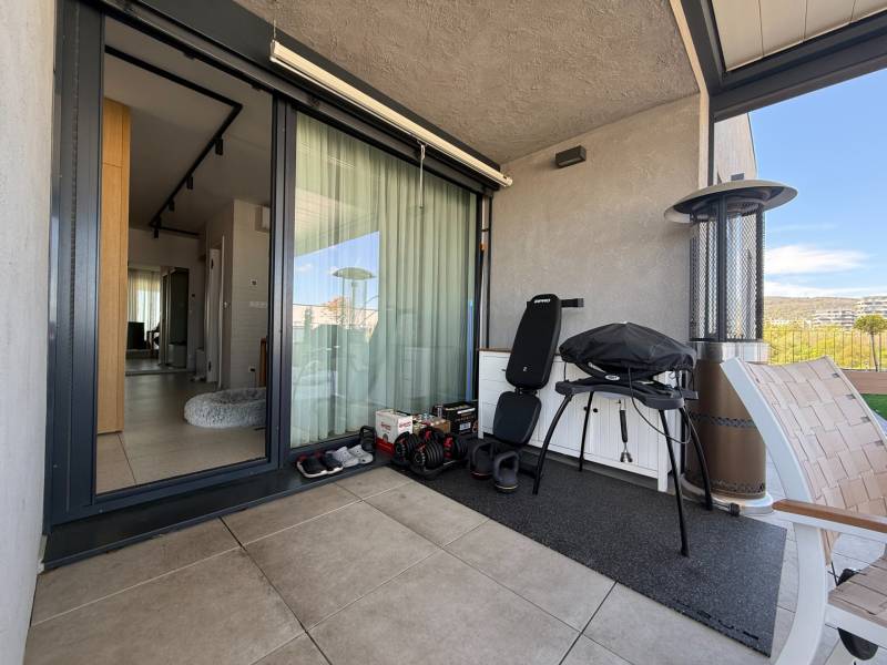 NUERA︱Penthouse s terasou s krásnymi výhľadmi v Dúbravke - Balkón 4-izbového bytu s grilom, stoličkou a výhľadom na Dúbravku.