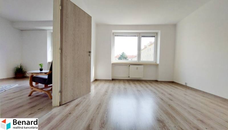 Na PRENÁJOM, VEĽKÝ 2 izb. TEHLOVÝ BYT, SÍDLISKO II., PREŠOV  - Interiér 2-izbového bytu s podlahou s dreveným dekorom a svetlými stenami.