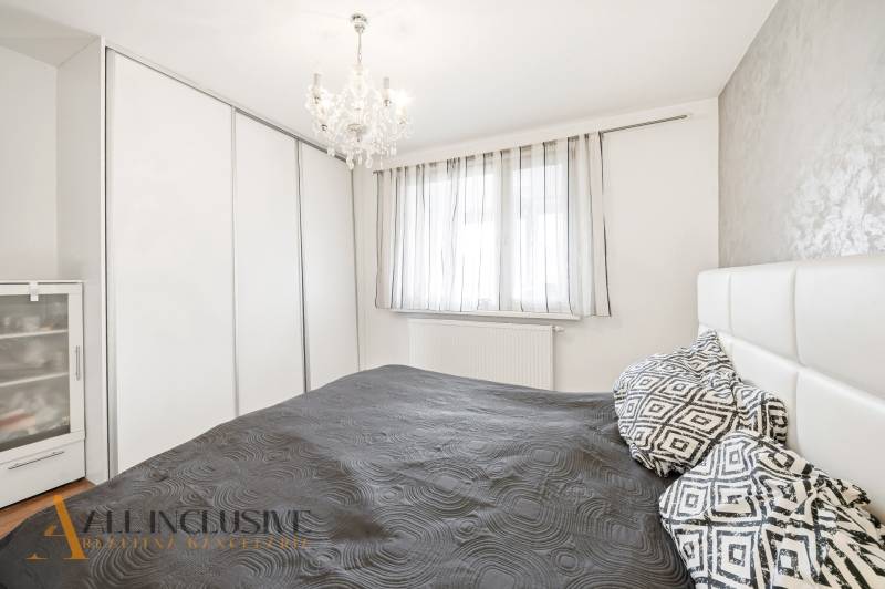 Na predaj 4-izb. byt s loggiou , Dunajská Streda - Spálňa v 4-izbovom byte s lusterom, šatníkovou skriňou a tmavým posteľným oblečením.