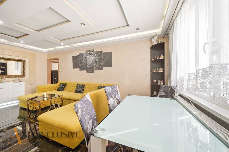 Na predaj 4-izb. byt s loggiou , Dunajská Streda - Obývačka v 4-izbovom byte s veľkou žltou sedačkou a skleneným stolom.