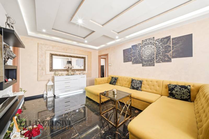 Na predaj 4-izb. byt s loggiou , Dunajská Streda - Obývacia izba s veľkými žltými pohovkami v 4-izbovom byte, s čiernou podlahou.