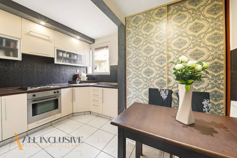 Na predaj 4-izb. byt s loggiou , Dunajská Streda - Kuchyňa v 4-izbovom byte s bielymi skrinkami, vstavanou rúrou a kvetinovou tapetou.