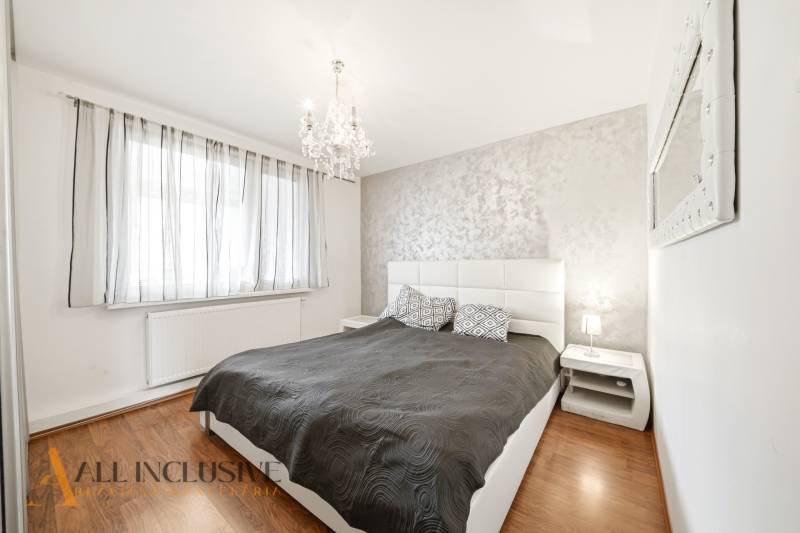 Na predaj 4-izb. byt s loggiou , Dunajská Streda - Spálňa v 4-izbovom byte s posteľou, lustrom a podlahou s dreveným dekorom.