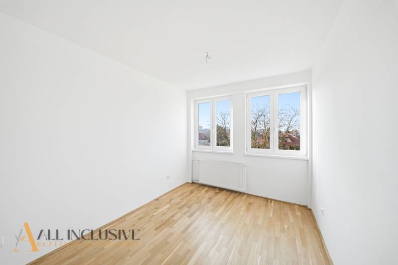 Na predaj zrekonštr. 3-izb. byt s balkónom, Dun.Streda - Svetlá izba s veľkými oknami a podlahou s dreveným dekorom v 3-izbovom byte.