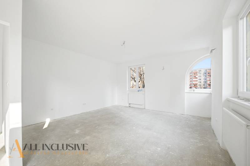 Na predaj zrekonštr. 3-izb. byt s balkónom, Dun.Streda - Prázdna izba v 3-izbovom byte s bielymi stenami a betónovou podlahou.