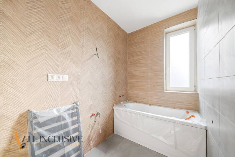 Na predaj zrekonštr. 3-izb. byt s balkónom, Dun.Streda - Kúpeľňa s vaňou a stenou v drevenom dekore v 3-izbovom byte.