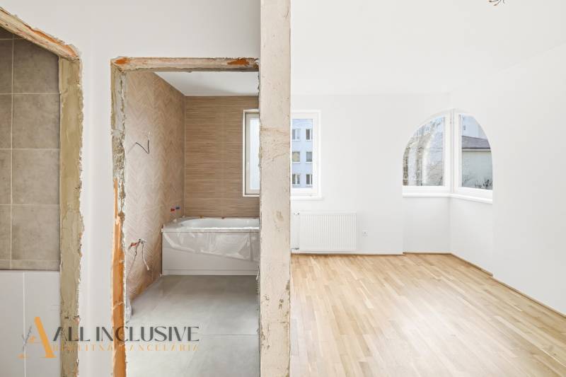 Na predaj zrekonštr. 3-izb. byt s balkónom, Dun.Streda - Interiér 3-izbového bytu, kúpeľňa so svetlou dlažbou a obývačka s podlahou s dreveným dekorom.