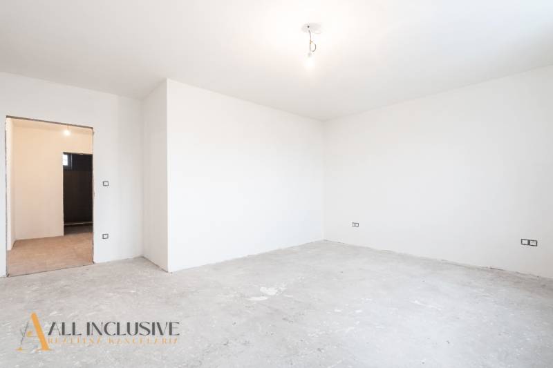 Na predaj poschodový 6-izbový rodinný dom, Horné Mýto - Prázdna miestnosť v rodinnom dome, biele steny, nedokončená podlaha bez dreveného dekoru.