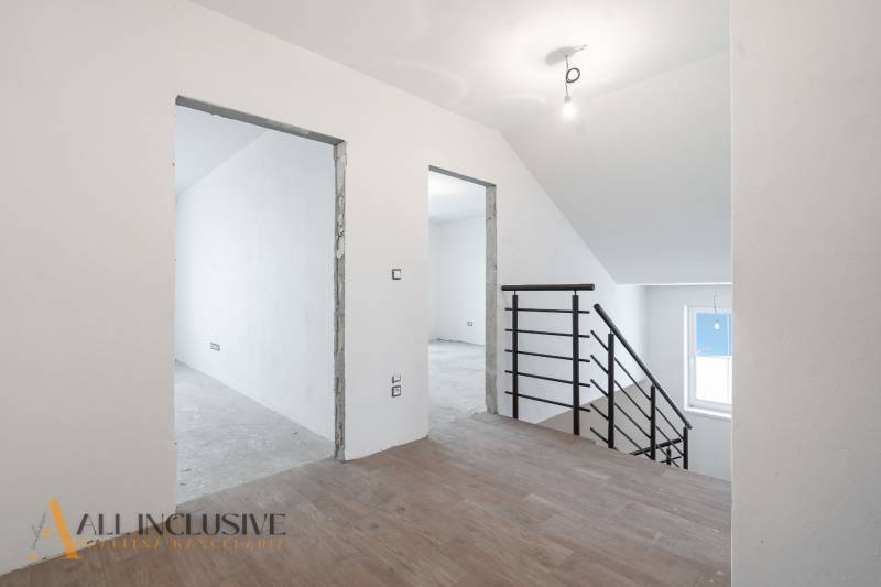 Na predaj poschodový 6-izbový rodinný dom, Horné Mýto - Nezariadený interiér rodinného domu s podlahou s dreveným dekorom a schodiskom.