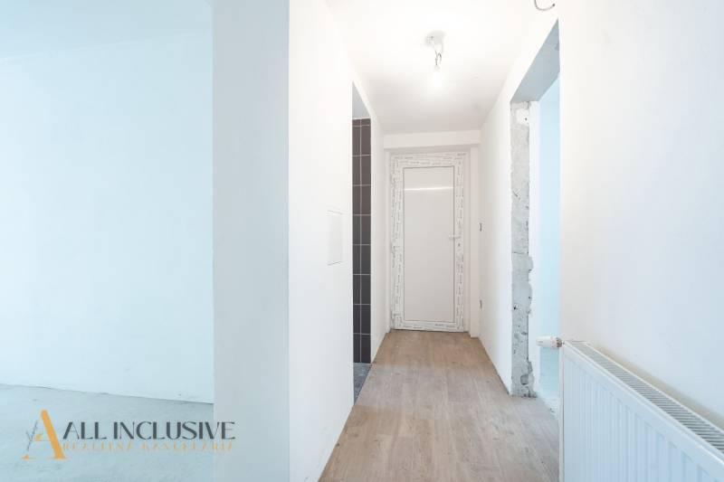 Na predaj poschodový 6-izbový rodinný dom, Horné Mýto - Chodba v rodinnom dome s podlahou s dreveným dekorom a bielou stenou.