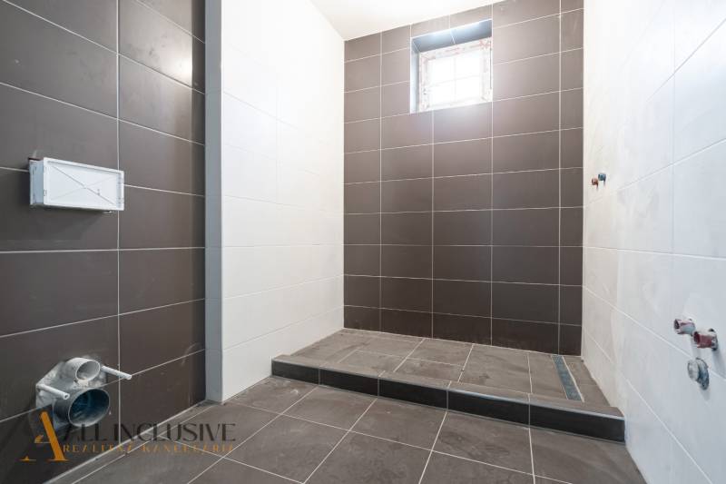 Na predaj poschodový 6-izbový rodinný dom, Horné Mýto - Kúpeľňa v rodinnom dome s čierno-bielymi kachličkami a malým oknom.