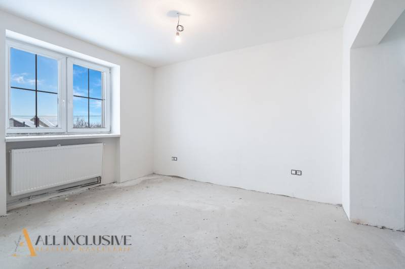 Na predaj poschodový 6-izbový rodinný dom, Horné Mýto - Prázdna miestnosť s veľkým oknom a radiátorom v rodinnom dome.