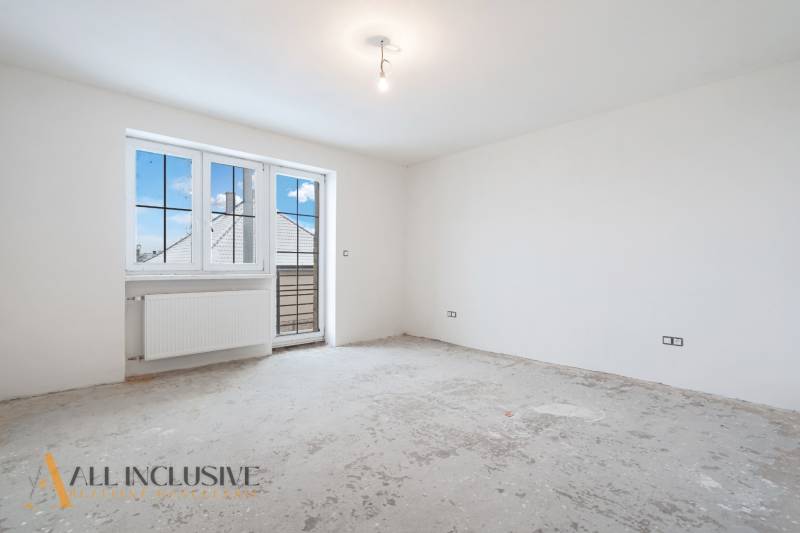 Na predaj poschodový 6-izbový rodinný dom, Horné Mýto - Prázdna izba s veľkým oknom v rodinnom dome bez podlahy s dreveným dekorom.