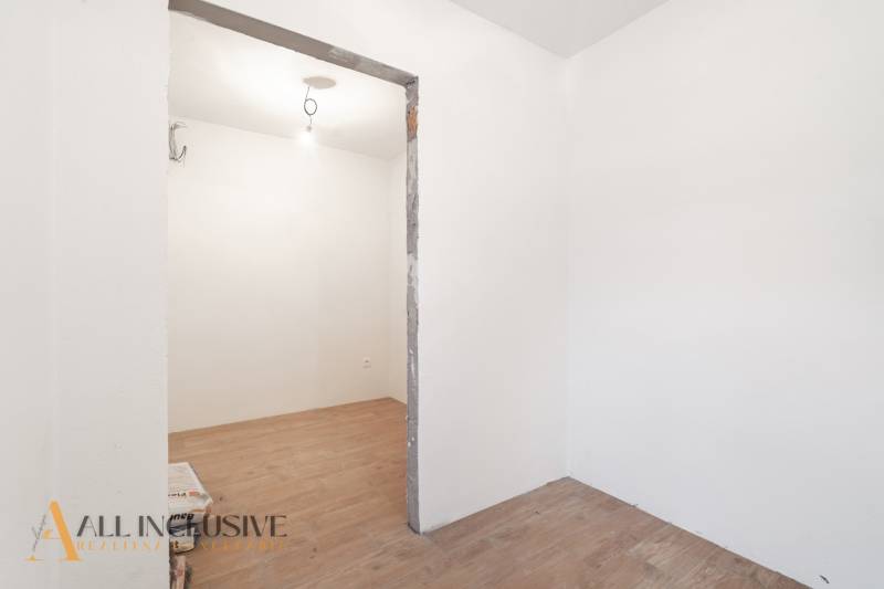 Na predaj poschodový 6-izbový rodinný dom, Horné Mýto - Miestnosť v rodinnom dome s bielymi stenami a podlahou s dreveným dekorom.