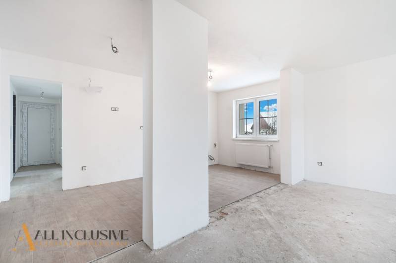 Na predaj poschodový 6-izbový rodinný dom, Horné Mýto - Priestranná miestnosť v rodinnom dome s veľkým oknom a podlahou s dreveným dekorom.