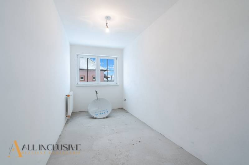 Na predaj poschodový 6-izbový rodinný dom, Horné Mýto - Prázdna miestnosť s bielymi stenami a oknom v rodinnom dome.