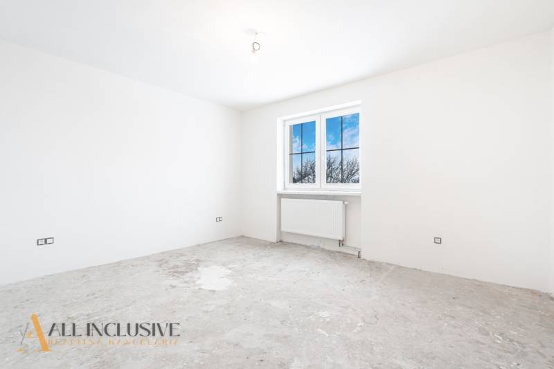 Na predaj poschodový 6-izbový rodinný dom, Horné Mýto - Prázdna miestnosť v rodinnom dome s oknom a nezarovnanou podlahou, čakajúca na dokončenie.